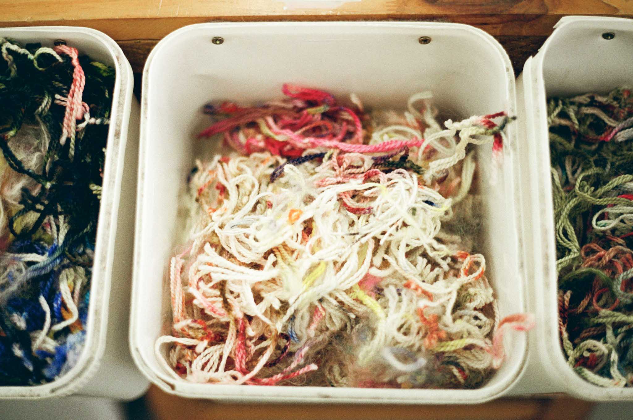 Scraps of textile waste are saved in buckets, and eventually sewn into a creative, vibrant scrappy fabric.