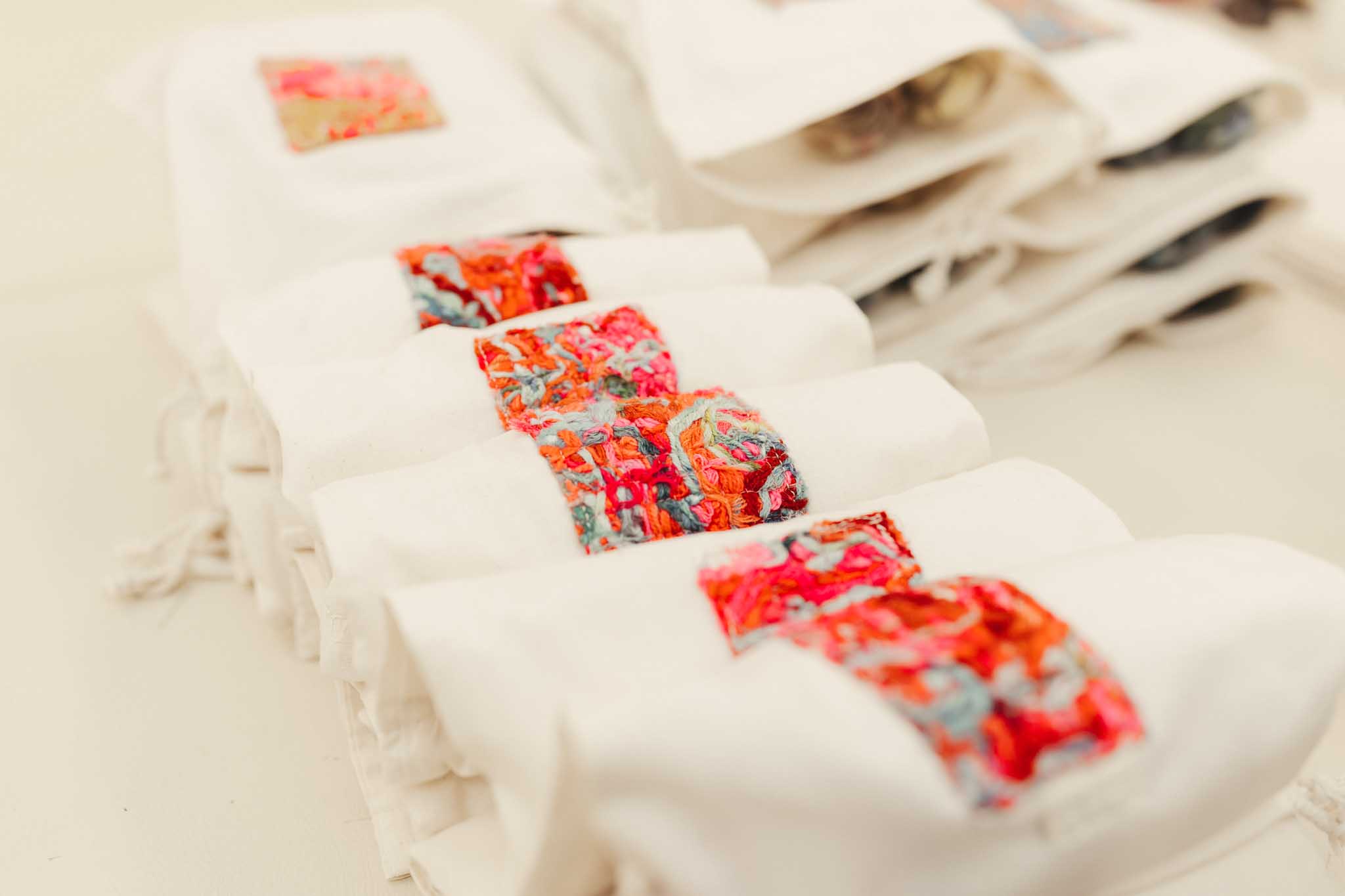 A line of project bags each have a square of the Cowgirlblues scrappy fabric sewn on top - merging sustainability and creativity into a beautiful, useful project bag.